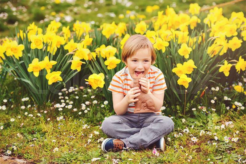 Cute little kid boy with chocolate Easter bunny celebrating traditional feast. Family, holiday, spring , carefree childhood concept, stock photo
