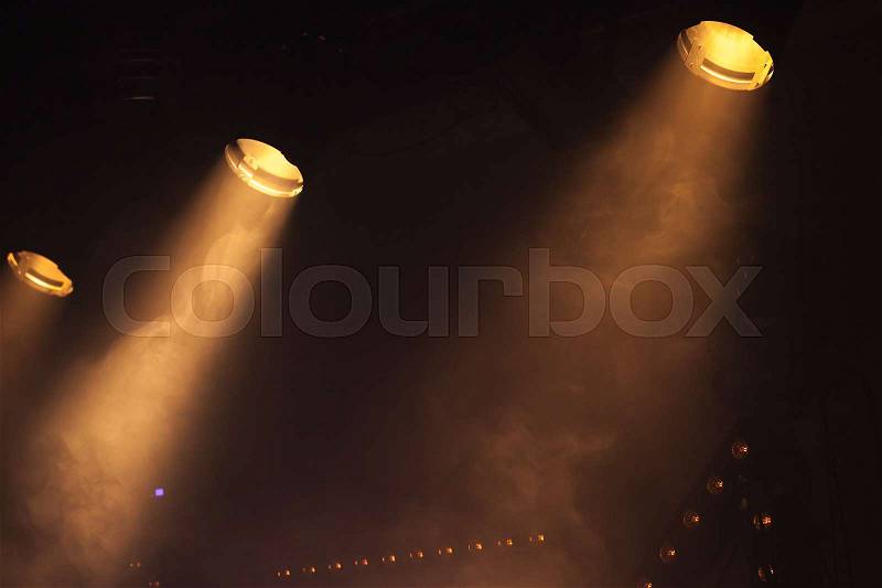 Scenic spot lights with bright beams in smoke, stage illumination, stock photo