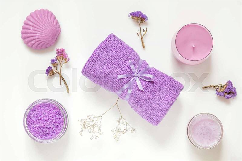 Spa products. Lavender bath salts, dry flowers, soap, cosmetic cream, candles and towel. Violet purple concept. Flat lay on white background, top view, stock photo