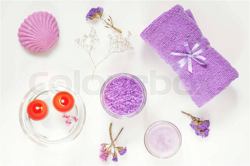Spa products. Lavender bath salts, dry flowers, soap, cosmetic cream, light candles and towel. Violet purple concept. Flat lay on white background, top view, stock photo