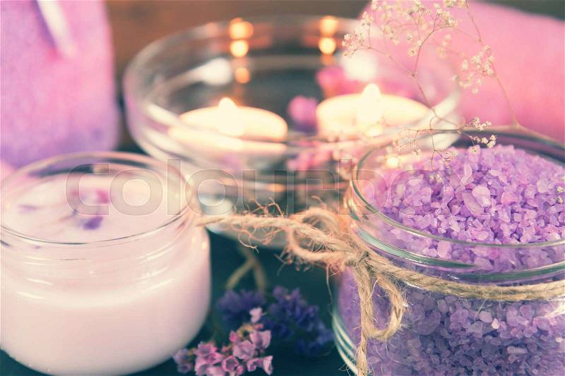 Spa products. Lavender bath salts, dry flowers, cosmetic cream, light candles and towel. Violet purple concept. Coloring and processing photo, stock photo