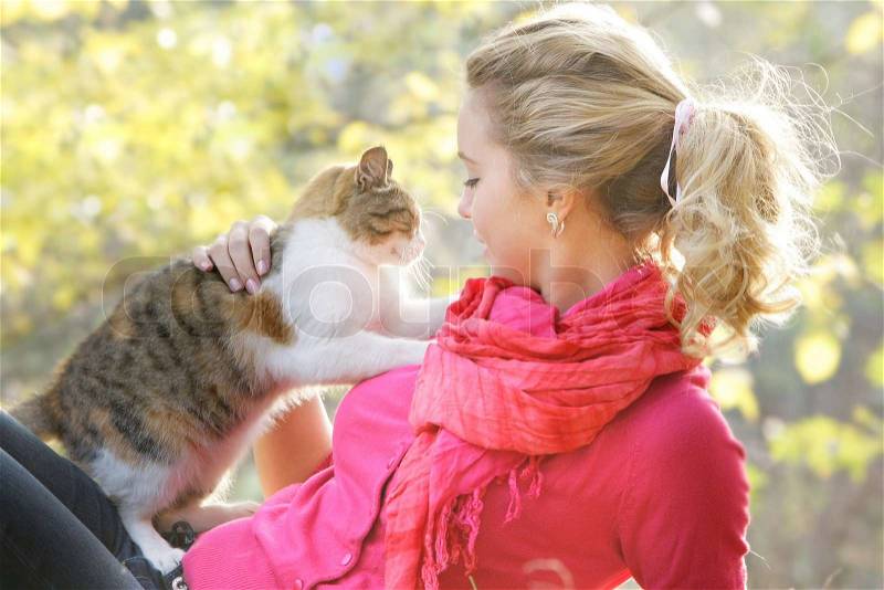 Young woman with cat on natural background, stock photo