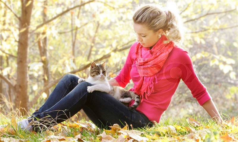 Young woman with cat on natural background, stock photo