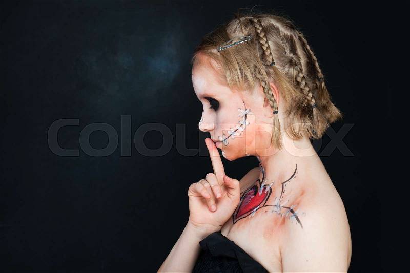 Young Girls with Love Makeup Holding her Finger to her Lips in a Gesture for Silence. Secret, Silent and Shushing, stock photo