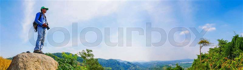 A man traveler standing alone on top of mountain , Outdoor activity in Summer season at tropical forest of Thailand , Panorama view, stock photo