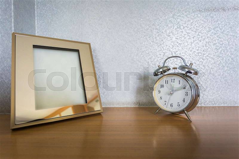 Table clock with photo frame in the bedroom , stock photo