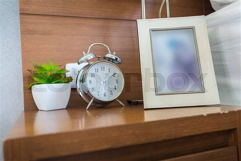 Table clock with photo frame in the bedroom , stock photo