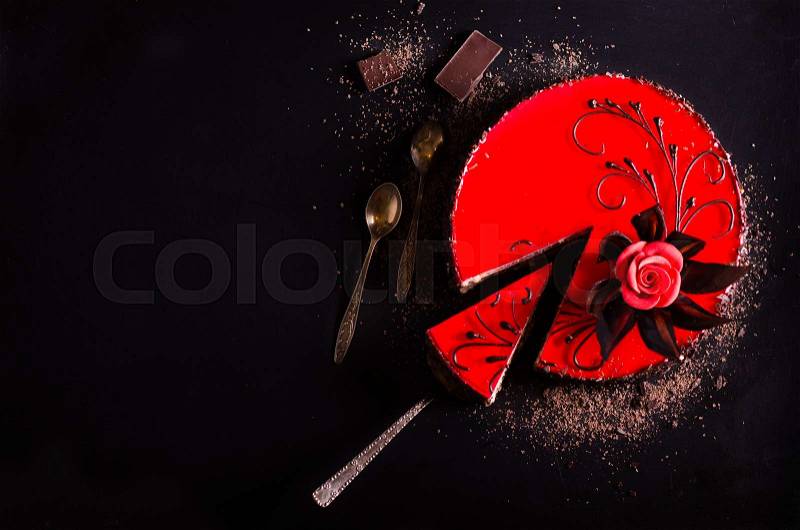 Red cake with rose, chocolate flower, on dark background. Free space for your text. Selective focus, stock photo