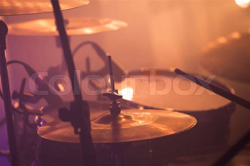 Warm toned live music photo background, drummer plays on rock drum set. Closeup photo, soft selective focus, stock photo