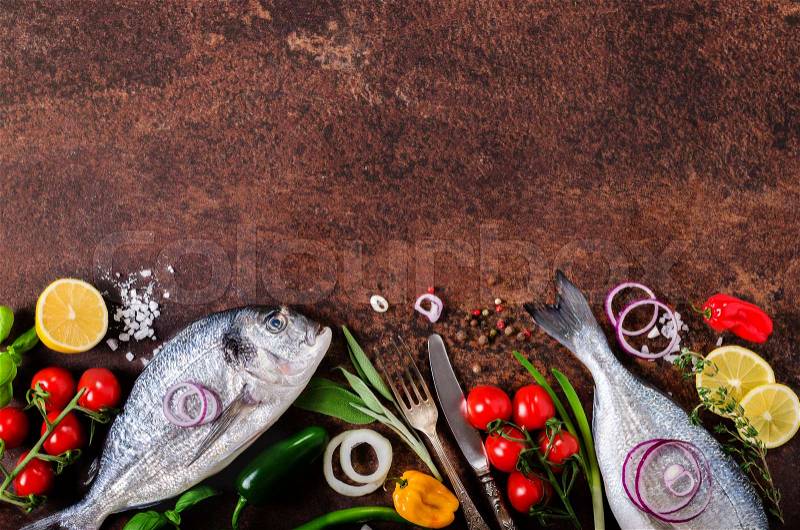 Dorada, fresh fish with vegetable, lemon, herbs, onion, paprika cherry tomatoes onion salton dark, stock photo