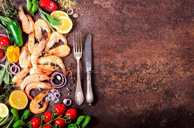 Fresh fish, shrimps with herbs, spices and vegetables on dark vintage background. Healthy food, diet or cooking concept, stock photo