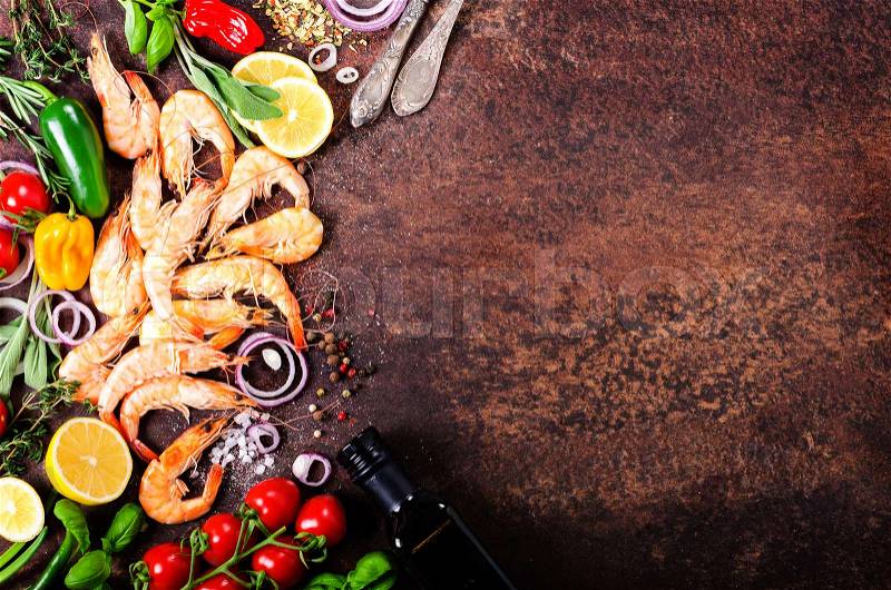 Fresh fish, shrimps with herbs, spices and vegetables on dark vintage background. Healthy food, diet or cooking concept. Free space for your background, stock photo