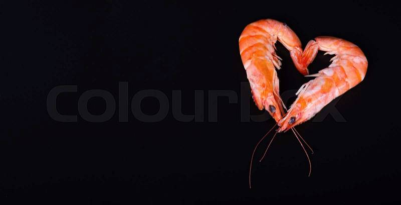Two shrimps forming a heart in a black background, stock photo