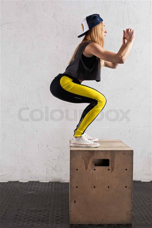 Cross-fit workout - fitness woman doing box jumps in the gym, stock photo