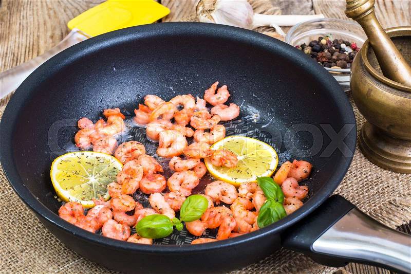 Small shrimp with lemon in a frying pan. Studio Photo, stock photo