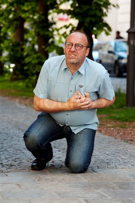 A man has a heart attack or stroke on the road, stock photo