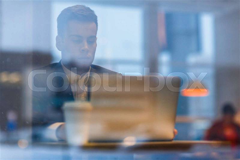 Young business leader or analyst reading financial statistics online, stock photo