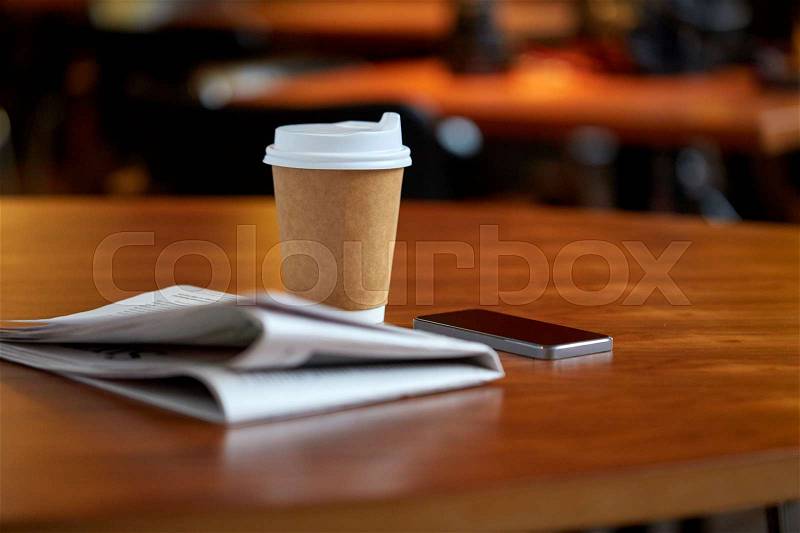 Technology, break, mass media and news concept - coffee drink in paper cup, smartphone and newspaper on cafe table, stock photo