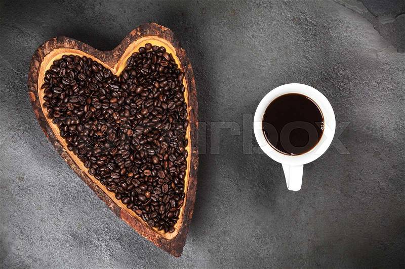 Coffee cup and beans in a heart shaped bowl, stock photo