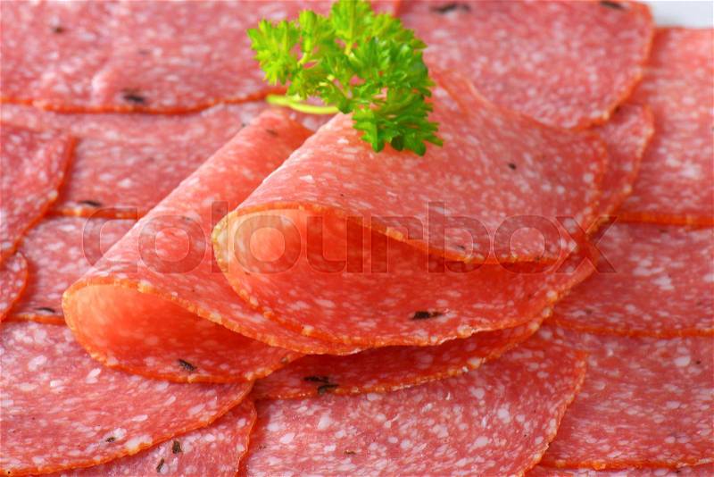 Thin slices of spicy salami - close up, stock photo