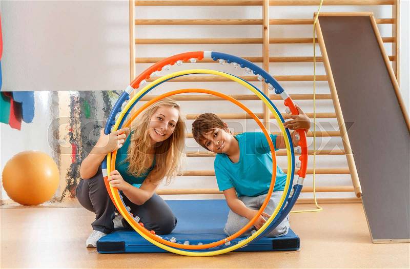 Happy, sports family, mother and son looking through hula hoops, stock photo