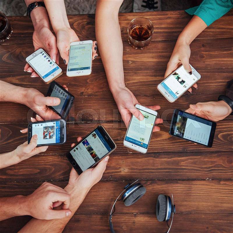 Top view hands circle using phone in cafe - Multiracial friends mobile addicted interior scene from above - Wifi connected people in bar table meeting - Concept of teamwork, stock photo