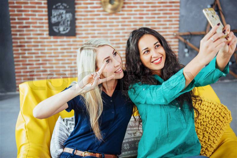 Two beautiful young woman doing selfie in a cafe, best friends girls together having fun, posing emotional lifestyle people concept, stock photo