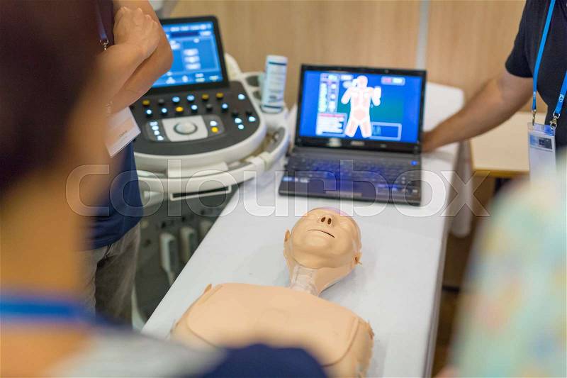 Team of medical doctor students learning to do advanced medical examination of patient with ultra sound scanner machine on ultrasound techniques workshop, stock photo