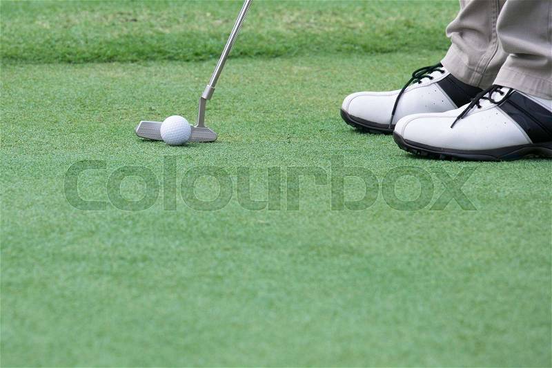 Golf player put a golf ball on a green, stock photo