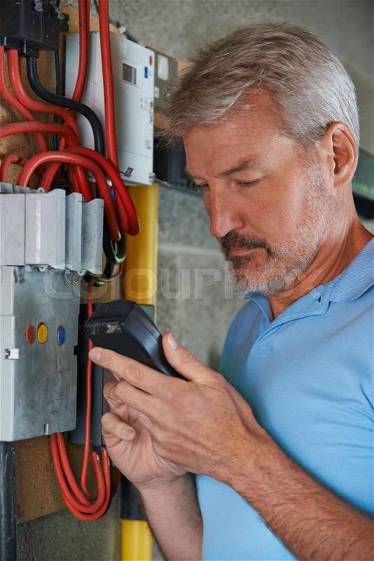 Man Taking Reading From Electricity Meter, stock photo