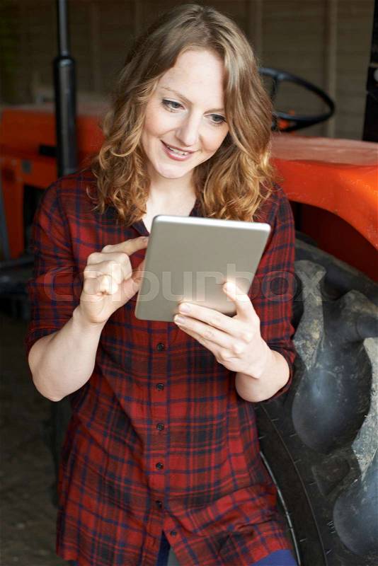 Female Agricultural Worker On Farm Using Digital Tablet, stock photo