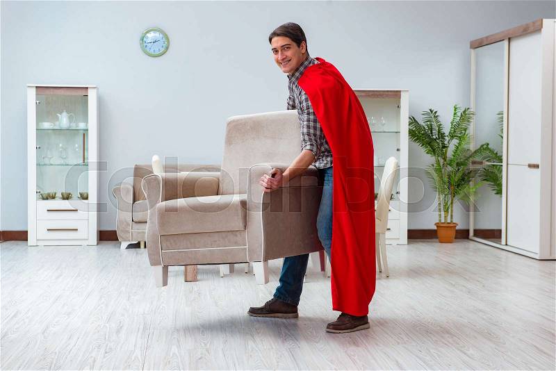 Super hero moving furniture at home, stock photo