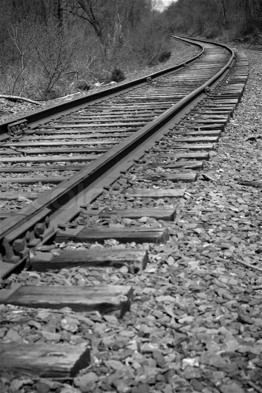 Railroad tracks curving off into the distance ahead - black and white, stock photo
