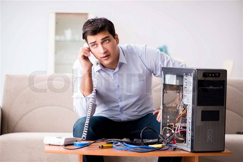 Angry customer trying to repair computer with phone support, stock photo