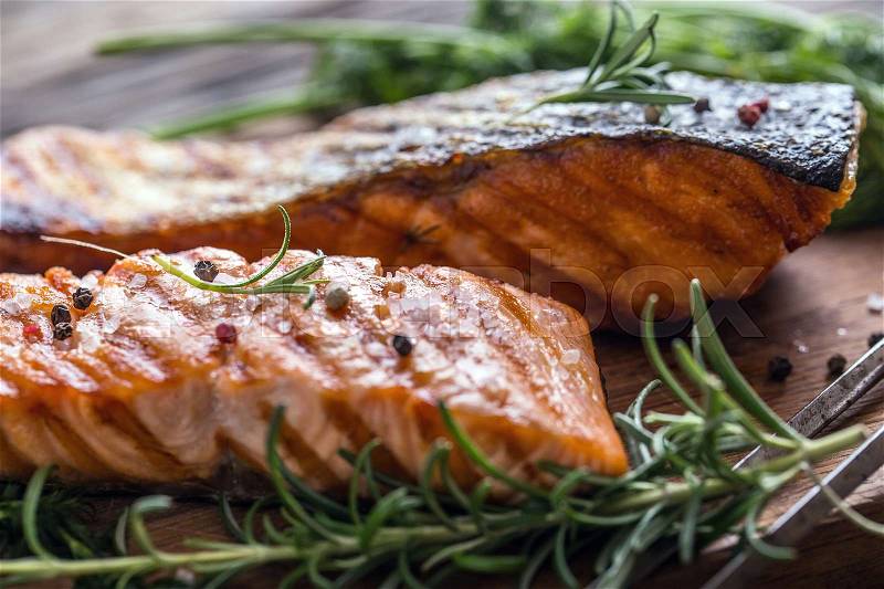 Salmon fillets. Grilled salmon, sesame seeds herb decoration on vintage pan or black slate board. fish roasted on an old wooden table.Studio shot, stock photo