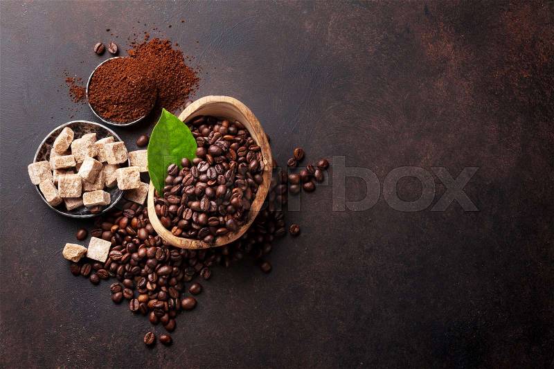 Coffee beans and ground powder on stone background. Top view with copy space for your text, stock photo