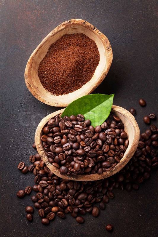 Coffee beans and ground powder on stone background. Top view, stock photo