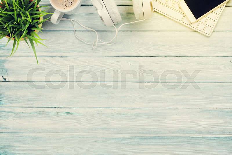 Headphones, phone and pc on wooden desk table. Music concept. Top view with copy space. Sunny toned, stock photo