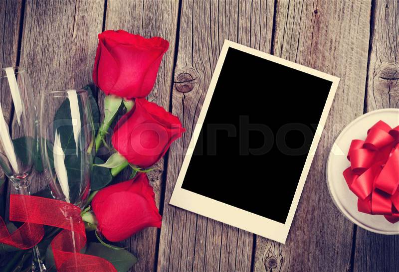 Valentines day photo frame, gift box and red roses on wooden table. Top view with copy space. Retro toned, stock photo