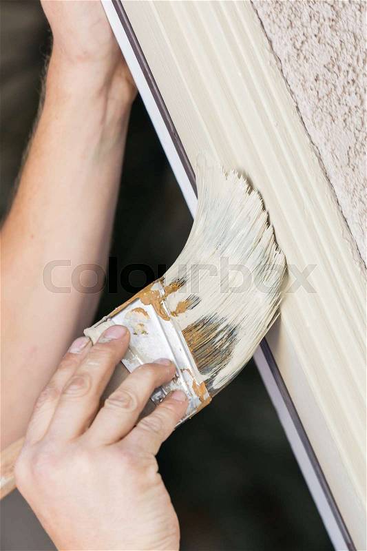 Professional Painter Cutting In With A Brush to Paint House Door Frame, stock photo
