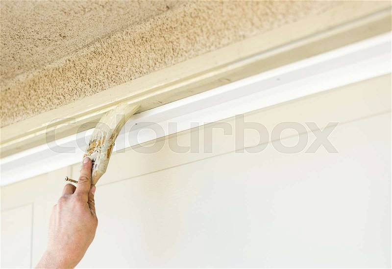 Professional Painter Cutting In With A Brush to Paint Garage Door Frame, stock photo