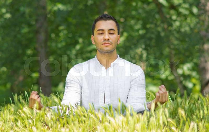 Happy young man rest on field-SMALL DOF, stock photo