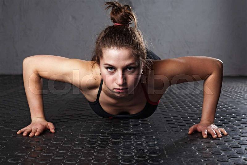 Fitness woman doing push-ups in the gym, close-up, stock photo