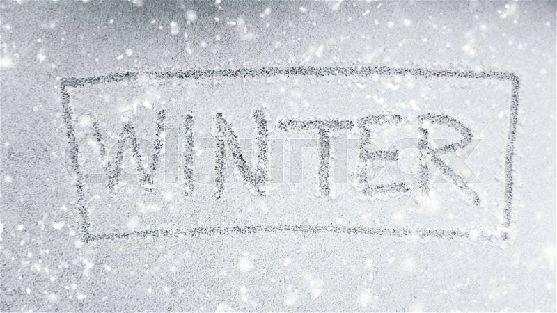 Handwriting winter word on light snow with snow falling effect, stock photo