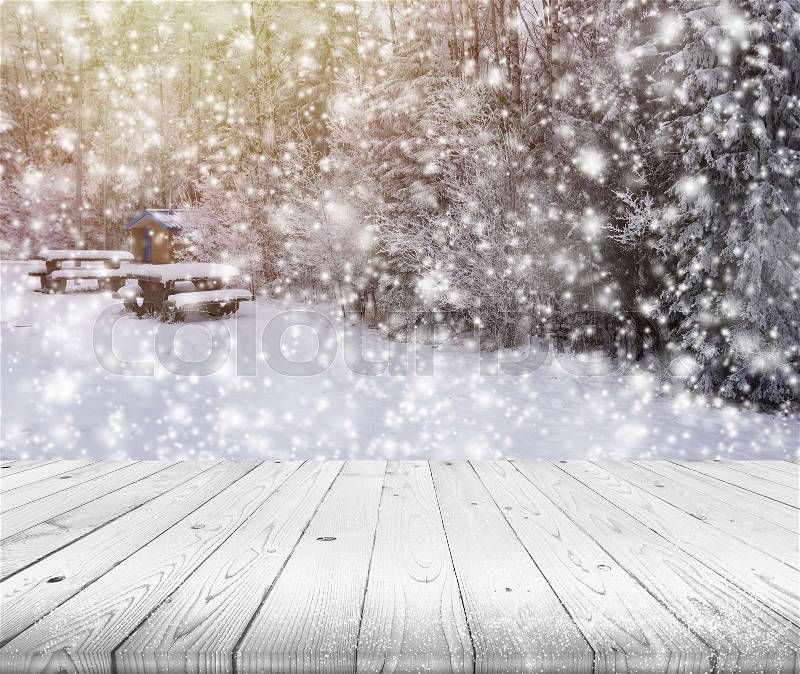 Wood table top on winter trees with snow effect background, stock photo