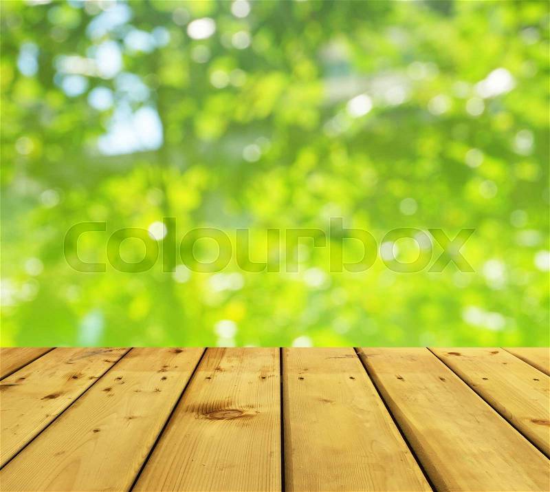 Wooden style floor and green nature bokeh for display of product or background, stock photo