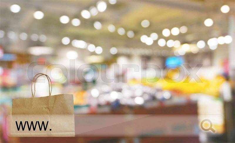 Reusable paper shopping bag against blur bokeh of store background online shopping concept, stock photo