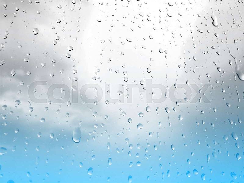 Raindrops on glass window, grey blue sky background, stock photo