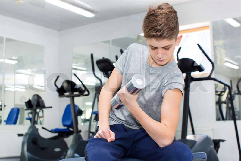 Teenage boy engaged in the gym hall, stock photo