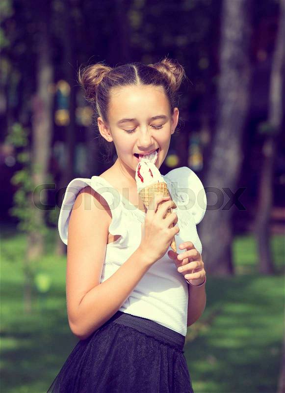 Girl eating ice cream in the park, stock photo